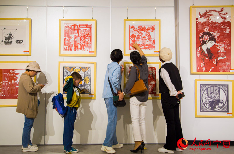 參觀者認真研究展出的剪紙作品。 人民網 張海峰攝