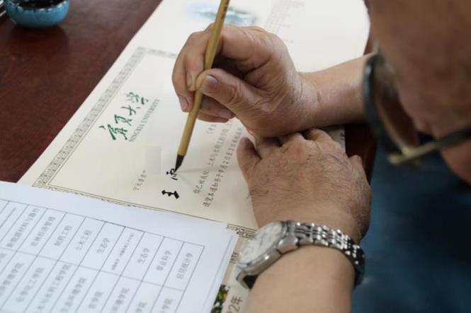 寧夏著名書法家丁生俊在手寫通知書。蘇暢攝