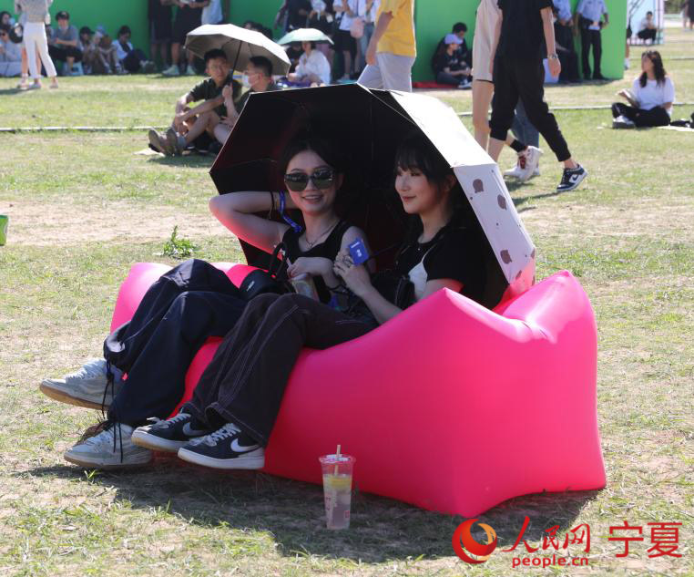 歌迷朋友在草地休閑打趣。人民網 李甜甜攝