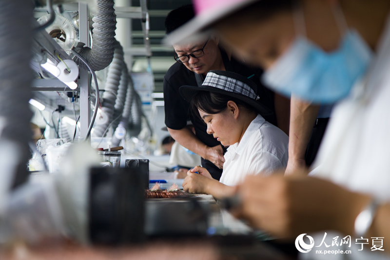 女工燒焊智能卡部件。 人民網 張海峰攝