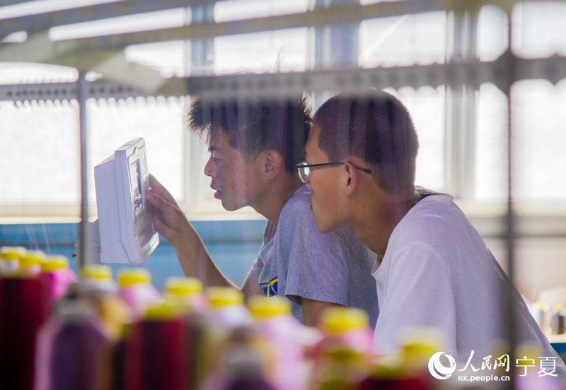 紡織車間工作人員設置儀器。 人民網 張海峰攝