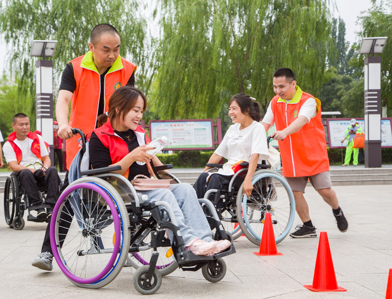 盲人選手與肢殘人選手緊密配合，進行繞樁比賽。 人民網 張海峰攝