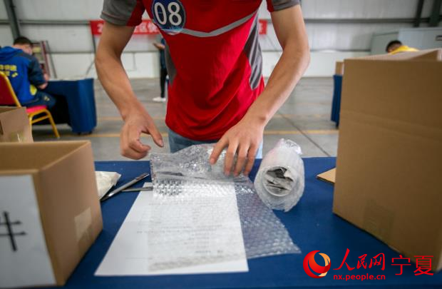 參賽選手包裝玻璃高腳杯。人民網 周航攝