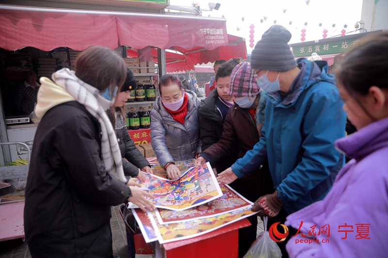 豐登鎮工作人員給市民發放年畫。人民網記者 閻夢婕攝