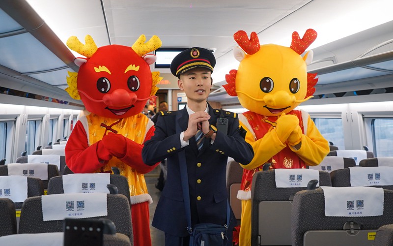 列車員與龍形人偶給乘客拜年。谷天朔攝
