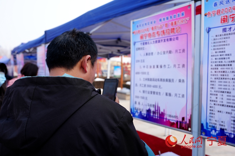 求職者正在用手機拍攝求職信息。人民網記者 閻夢婕攝