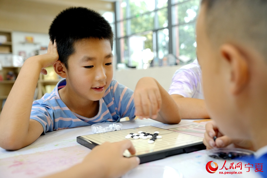 7月23日，寧夏銀川市居安家園社區“暑托班”里，兩名小朋友正在下圍棋。人民網記者 閻夢婕攝