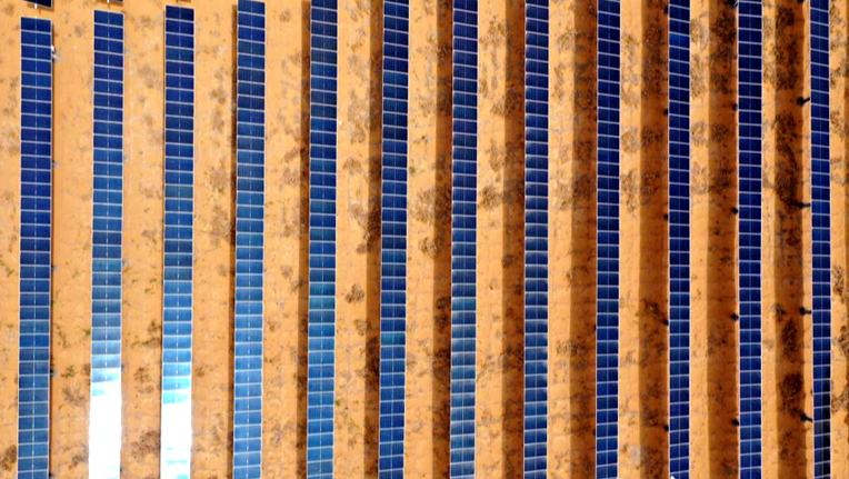 行進中國丨沙海變“藍?！?#13;站在寧夏中衛市的沙丘上眺望，騰格里沙漠新能源基地一排排光伏板整齊鋪設，金色沙漠成為靛藍海洋