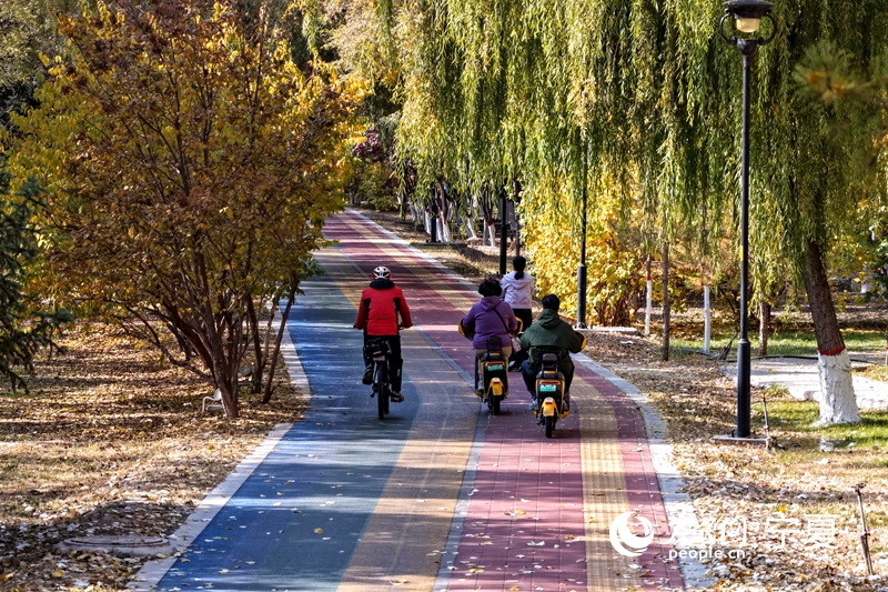 市民騎行在慢行小道，與美景伴行。人民網記者 梁宏鑫攝