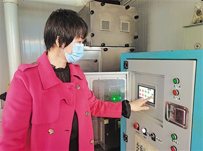     在自治區生態環境廳職工食堂廚余垃圾處理設備間，工作人員正在操作設備處理廚余垃圾。